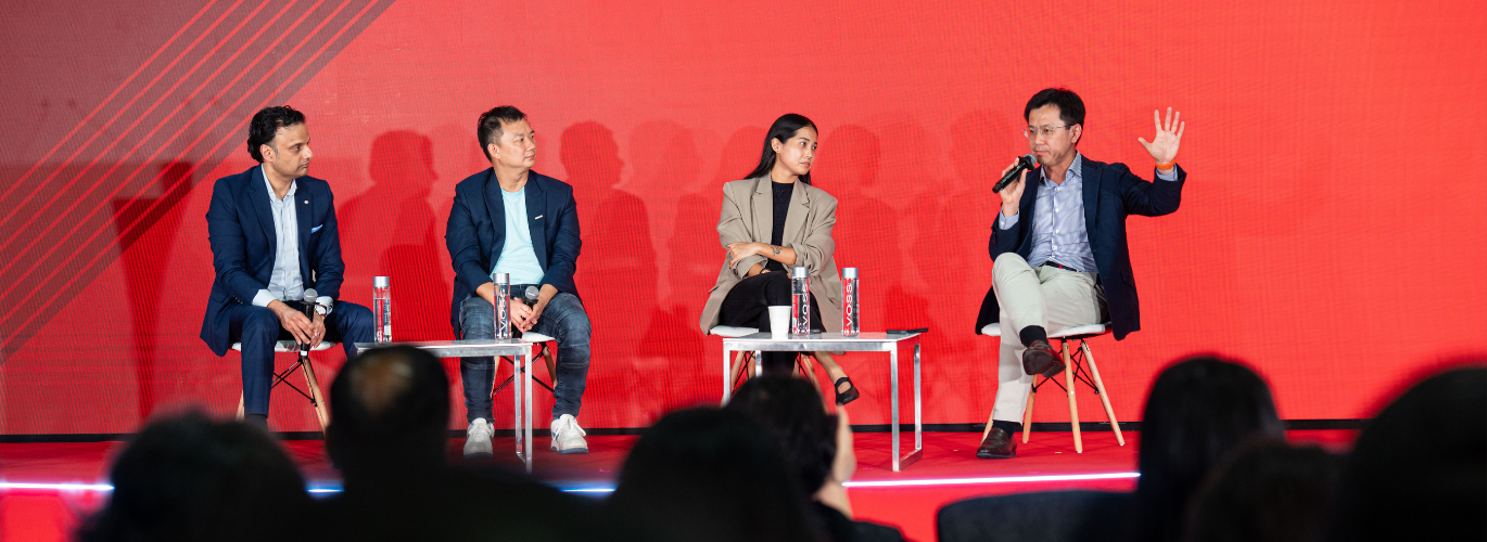 A photograph of four panelists presenting on the Converge Stage.